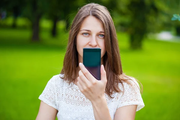 Krásná mladá dívka ukazuje váš smartphone obrazovky — Stock fotografie