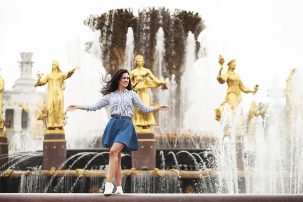 Ung vacker brunett flicka poserar nära staden fountain — Stockfoto
