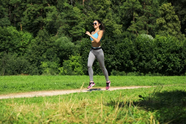 Atletik mutlu esmer kadın bir çayırda çalışma dışarı — Stok fotoğraf