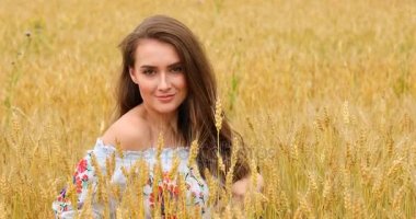 Bir buğday alan arka planda poz genç güzel kız 