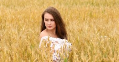 Bir buğday alan arka planda poz genç güzel kız 