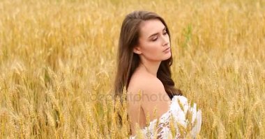 Bir buğday alan arka planda poz genç güzel kız 