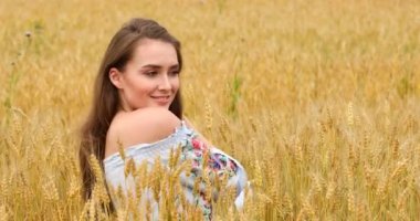 Bir buğday alan arka planda poz genç güzel kız 