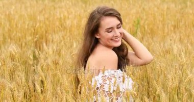 Bir buğday alan arka planda poz genç güzel kız 