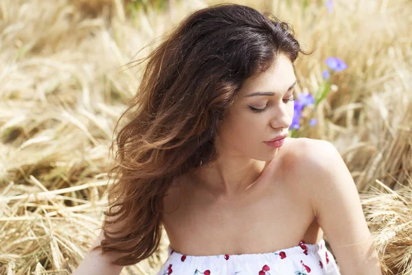 Altın buğday alan arka plan üzerinde genç kadın