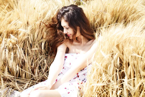 Altın buğday alan arka plan üzerinde genç kadın