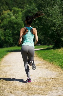 Atletik mutlu esmer kadın bir çayırda çalışma dışarı