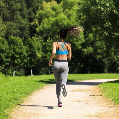 Atletik mutlu esmer kadın bir çayırda çalışma dışarı