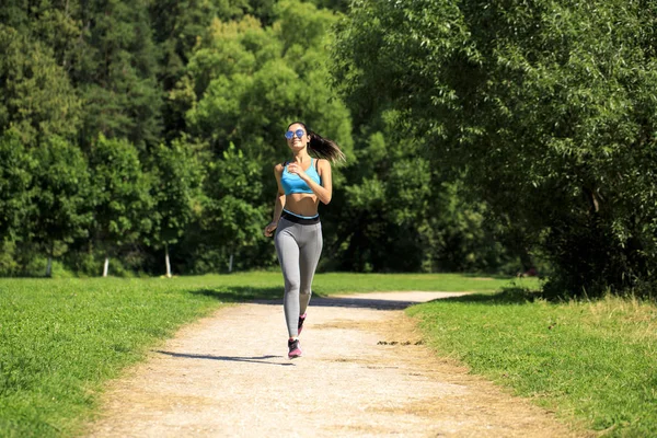 Atlética morena feliz mujer haciendo ejercicio en un prado —  Fotos de Stock