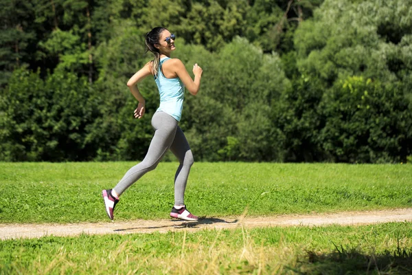 Athletisch glücklich brünette Frau beim Training auf einer Wiese — Stockfoto