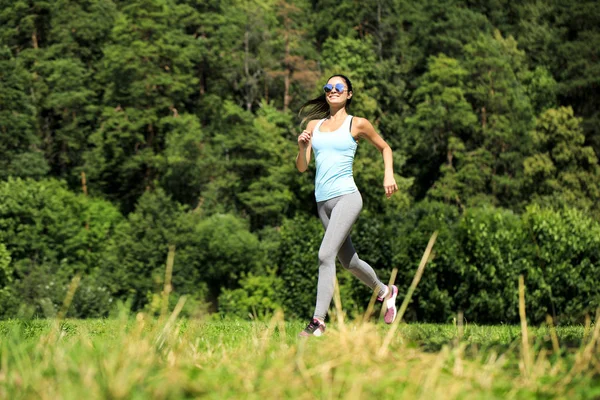 Atlético feliz morena mulher trabalhando em um prado — Fotografia de Stock