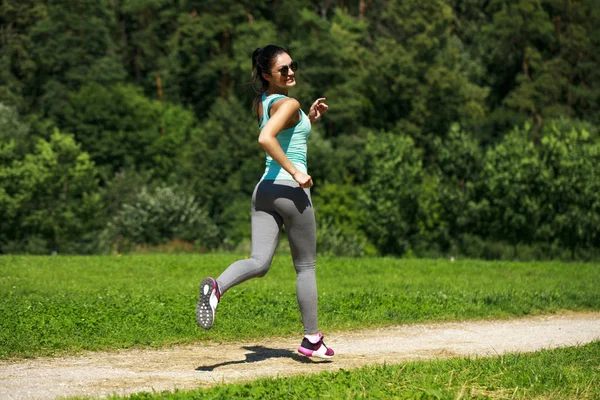 Atletik mutlu esmer kadın bir çayırda çalışma dışarı — Stok fotoğraf