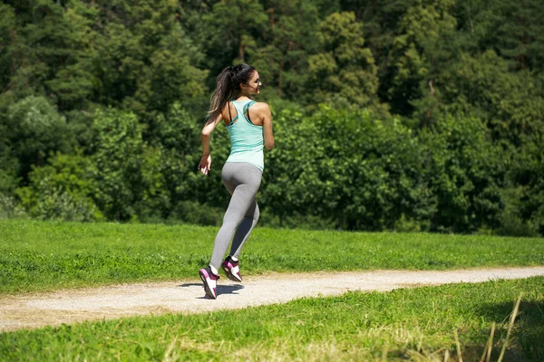 Atletik mutlu esmer kadın bir çayırda çalışma dışarı — Stok fotoğraf