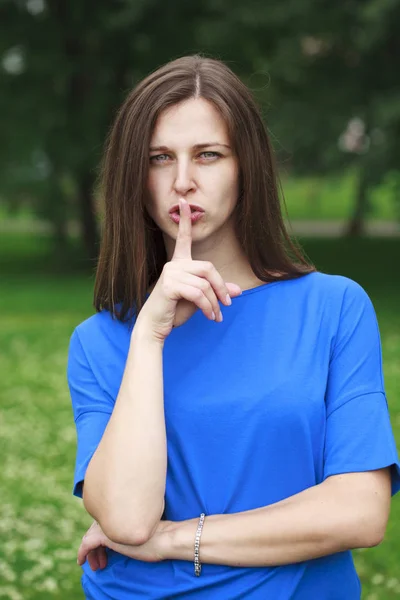 Junge schöne brünette Frau hat Zeigefinger auf die Lippen gelegt als sig — Stockfoto