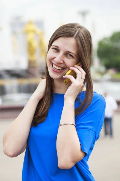 Mooie jonge brunette vrouw bellen via de telefoon — Stockfoto