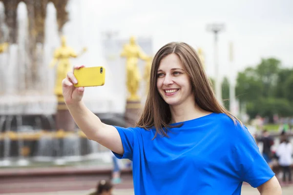 Vacker brunett klänning att ta bilder av sig själv på en cellpho — Stockfoto