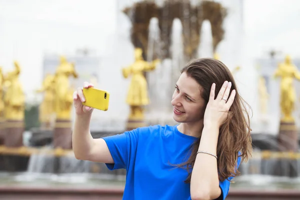 Hermoso vestido morena tomando fotos de sí misma en un cellpho — Foto de Stock