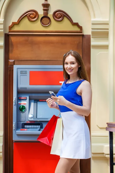 Femme brune heureuse retirant de l'argent de la carte de crédit au distributeur automatique — Photo