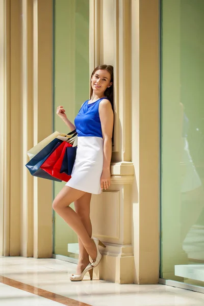 Felice donna bruna con un po 'di shopping bag rosso — Foto Stock