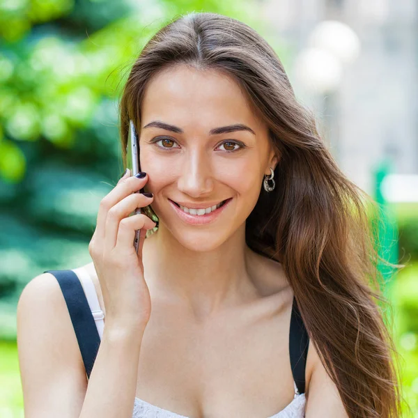 Güzel koyu saçlı genç kadın cep telefonunuza konuşan portresi — Stok fotoğraf