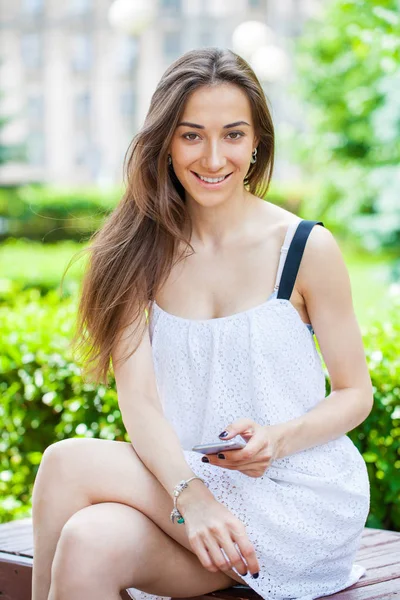 Portrait of beautiful dark haired young woman speaking on mobile — Stock Photo, Image