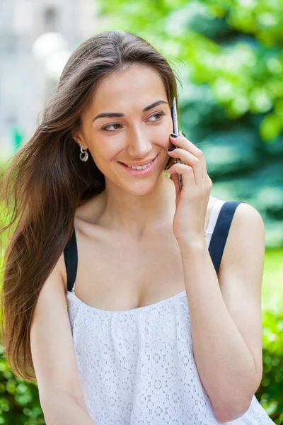 Güzel koyu saçlı genç kadın cep telefonunuza konuşan portresi — Stok fotoğraf