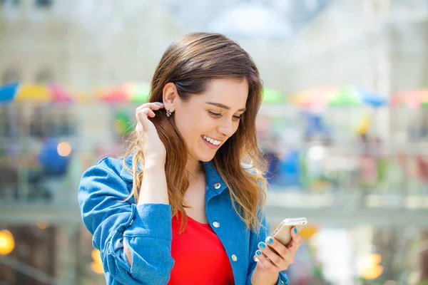 Junge brünette Frau liest eine Nachricht am Telefon — Stockfoto