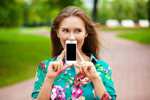 Jovem menina bonita mostrando sua tela do smartphone — Fotografia de Stock