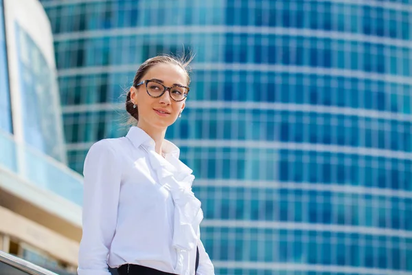 Junge Geschäftsfrau vor dem Hintergrund von Wolkenkratzern — Stockfoto