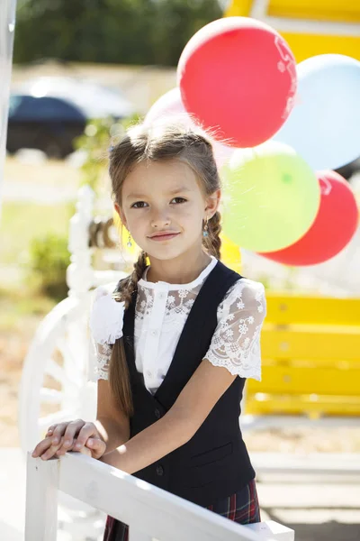 Retrato de una hermosa niña de primer grado en uniforme escolar — Foto de Stock