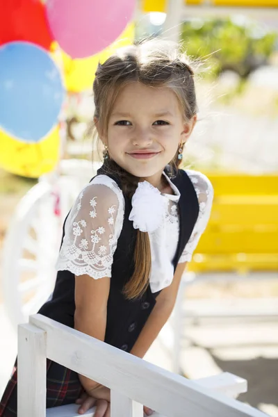 Retrato de uma bela menina do primeiro ano no uniforme da escola — Fotografia de Stock