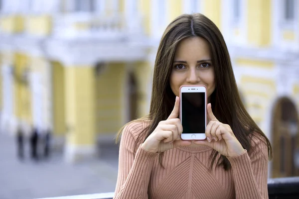 Krásná mladá dívka ukazuje váš smartphone obrazovky — Stock fotografie