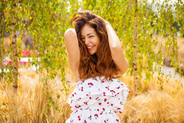 Mujer joven sobre un fondo de campo de trigo dorado — Foto de Stock