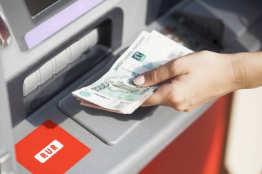 Woman hand withdrawing money from outdoor bank ATM clipart