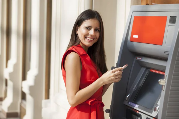 Mulher feliz retirando dinheiro do cartão de crédito no ATM — Fotografia de Stock
