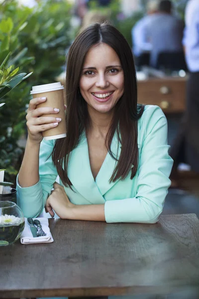 Jonge mooie brunette vrouw zittend in een restaurant — Stockfoto