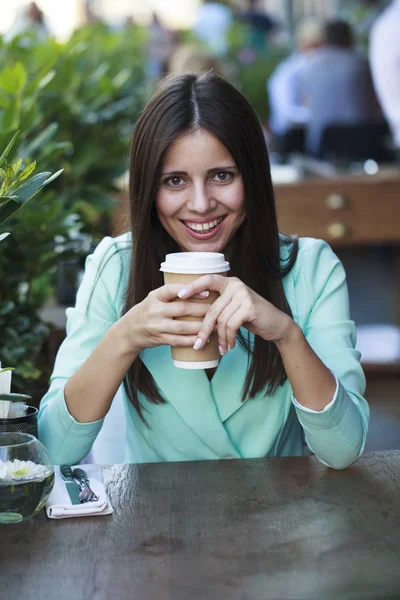 Junge schöne brünette Frau sitzt in einem Restaurant — Stockfoto