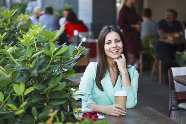 Bir restoranda oturan genç güzel esmer kadın