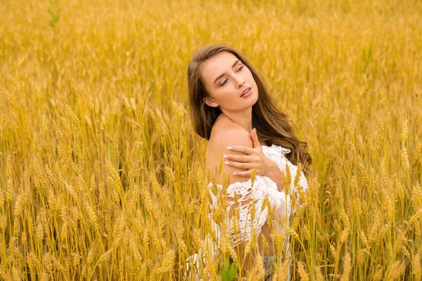 Portrait of a young girl on a background of golden wheat field — Stock Photo, Image