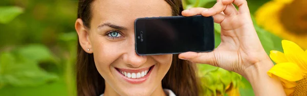 युवा सुंदर मुलगी आपला स्मार्टफोन स्क्रीन दर्शविते — स्टॉक फोटो, इमेज