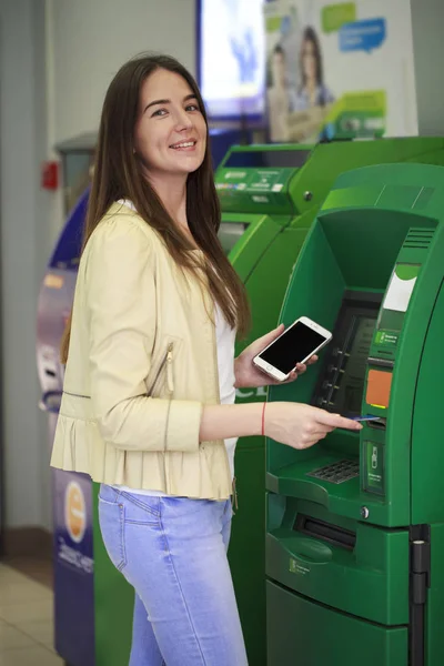 Mujer morena feliz retirando dinero de la tarjeta de crédito en el cajero automático — Foto de Stock