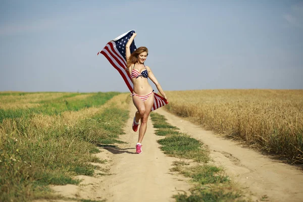 Σέξι γυναίκα σε σέξι αμερικανική σημαία μπικίνι σε έναν τομέα σίτου — Φωτογραφία Αρχείου