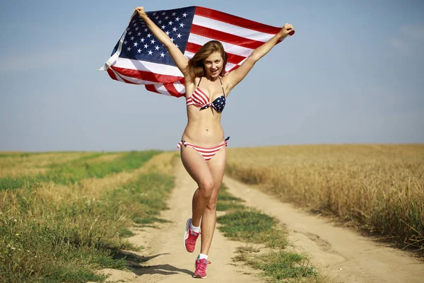 Sexy kobieta w bikini sexy amerykańską flagę w polu pszenicy — Zdjęcie stockowe