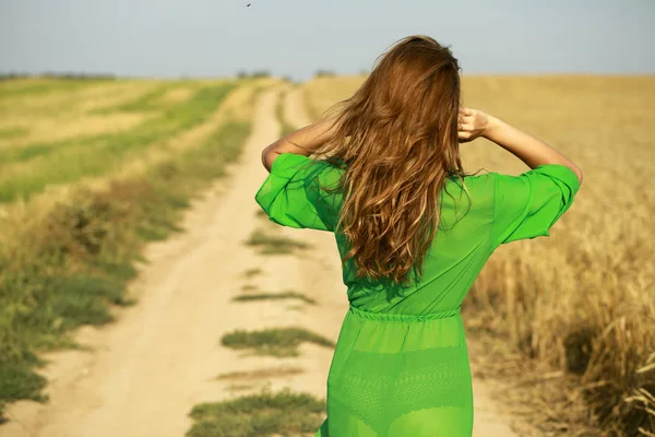 Portrait of a young girl on a background of golden wheat field — Stock Photo, Image