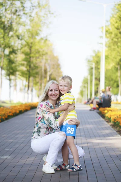 Jovem mãe e filho brincando no parque de verão — Fotografia de Stock