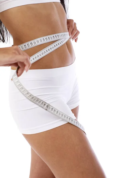 Slender girl measures a waist with a centimeter — Stock Photo, Image