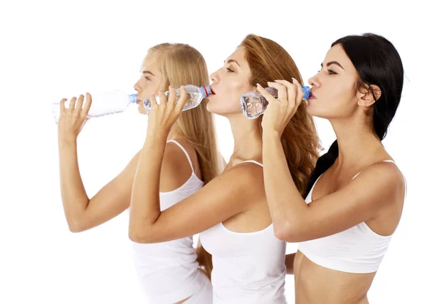 Mujeres de fitness. Tres jóvenes hermosas novias bebiendo agua —  Fotos de Stock