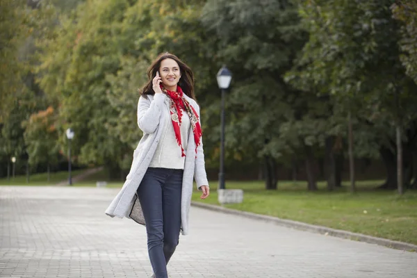 Portret szczęśliwy młody brunetka kobieta mówiąc beżowy płaszcz na — Zdjęcie stockowe