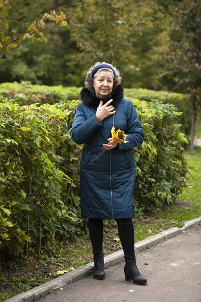 Gray haired elderly woman in an autumn park — Stock Photo, Image