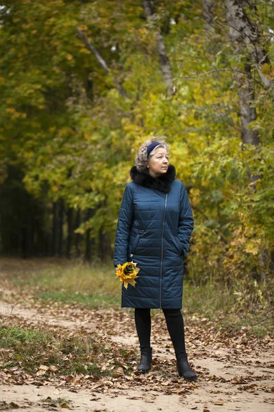 Donna anziana dai capelli grigi in un parco autunnale — Foto Stock